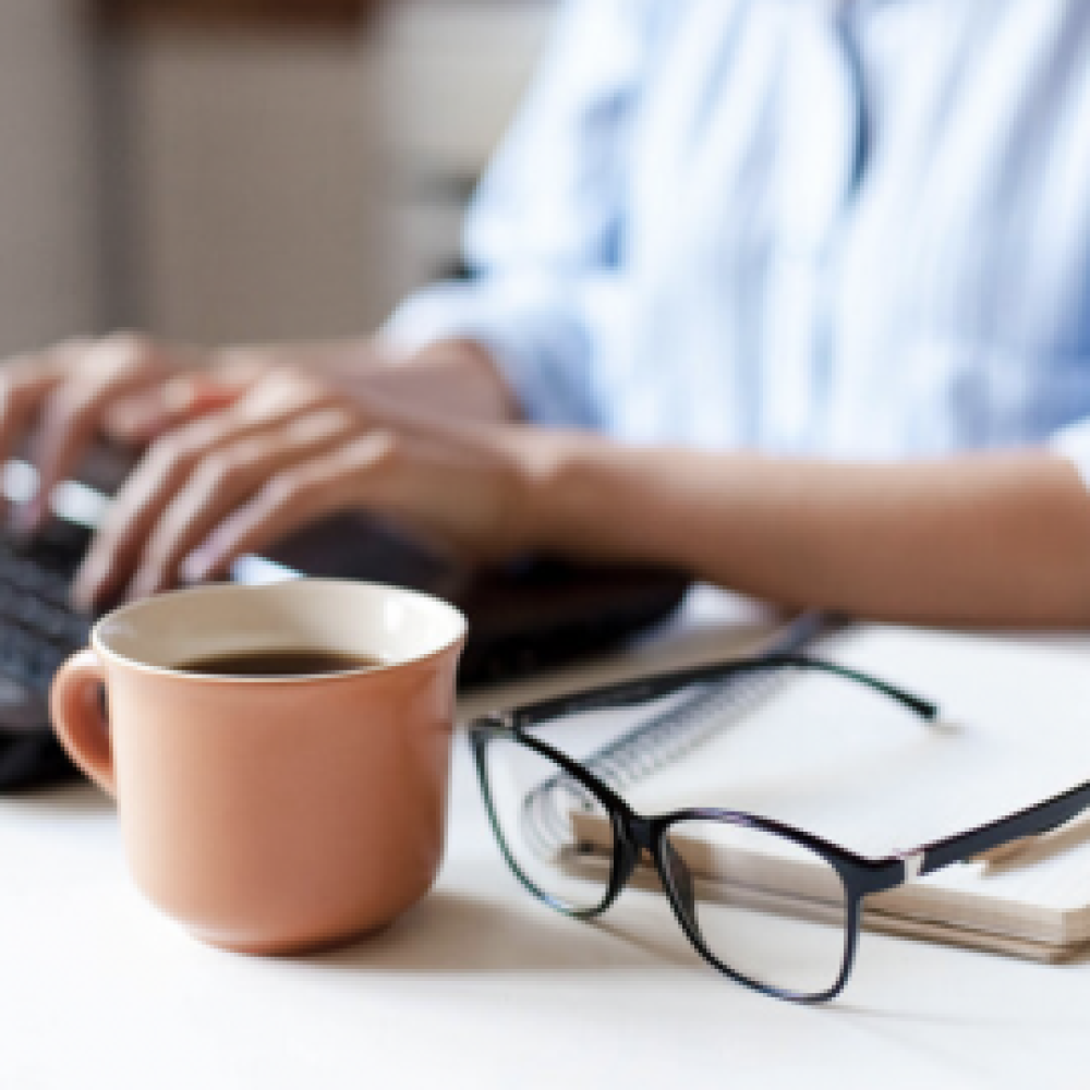 woman working at desk with coffee
